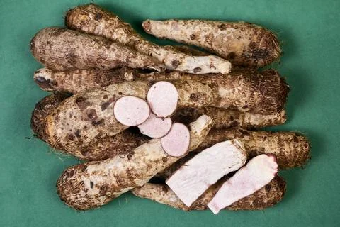 Closeup of taro root vegetable, eddo malanga, green background Stock Photos