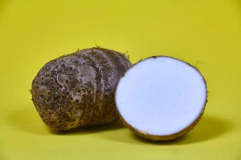 Closeup of taro root vegetable, eddo malanga, yellow background Foto stock