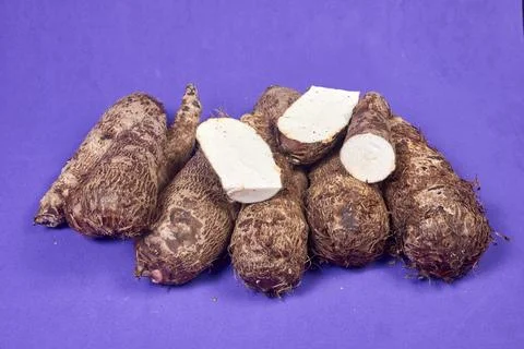 Closeup of taro root vegetable, eddo malanga, purple background Foto stock