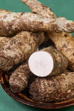 Closeup of taro root vegetable, eddo malanga, green background Stock Photos