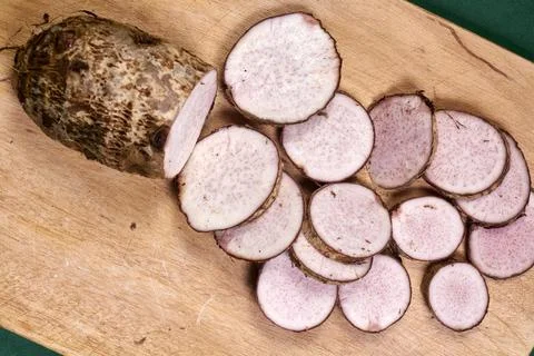 Closeup of taro root vegetable, eddo malanga, green background Stock Photos