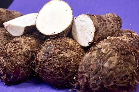 Closeup of taro root vegetable, eddo malanga, purple background Stock Photos