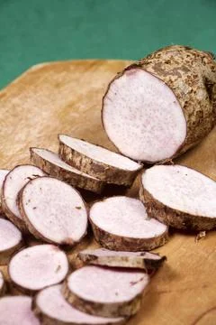 Closeup of taro root vegetable, eddo malanga, green background Stock Photos