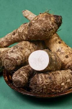 Closeup of taro root vegetable, eddo malanga, green background Stock Photos