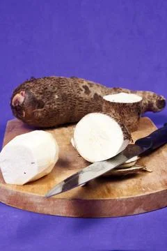 Closeup of taro root vegetable, eddo malanga, purple background Stock Photos