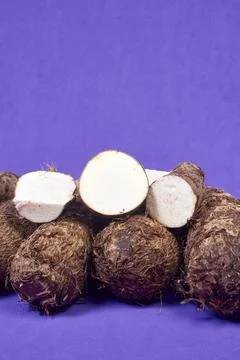 Closeup of taro root vegetable, eddo malanga, purple background Stock Photos