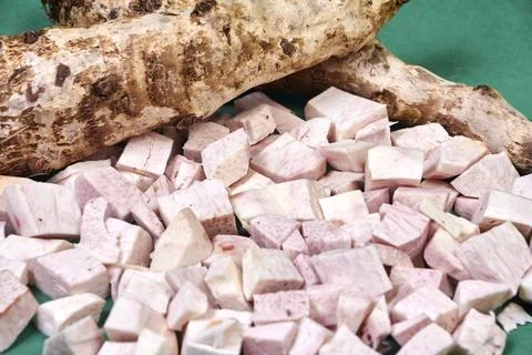 Closeup of taro root vegetable, eddo malanga, green background Stock Photos