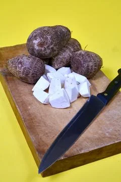 Closeup of taro root vegetable, eddo malanga, yellow background Stock Photos