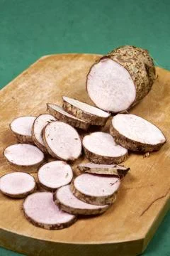 Closeup of taro root vegetable, eddo malanga, green background Stock Photos