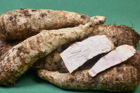 Closeup of taro root vegetable, eddo malanga, green background Stock Photos