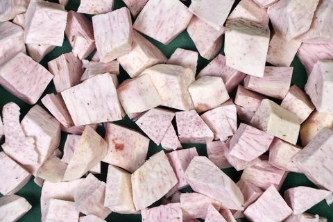 Closeup of taro root vegetable, eddo malanga, green background Stock Photos