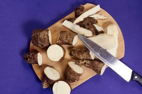 Closeup of taro root vegetable, eddo malanga, purple background Stock Photos