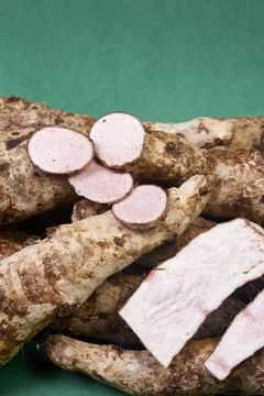 Closeup of taro root vegetable, eddo malanga, green background Stock Photos