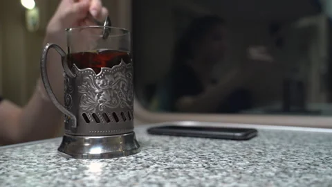 Closeup of a tea glass stands on a table in a passenger train carriage Stock Footage 263473752
