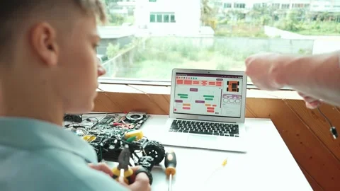 Closeup of teacher picking wires while boy holding electric tool. Edification Stock Footage 271471337