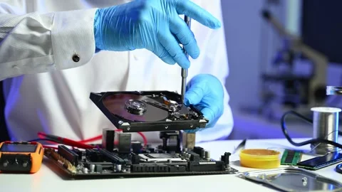 Closeup of technician using screwdriver to fix an open hard drive near a mo.. Stock Footage 312773860