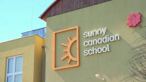 Closeup on the text on a school wall: Sunny Canadian School on a sunny day Stock-Footage 79521385