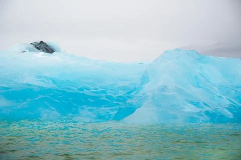 Closeup texture of bright blue iceberg. Enviromental issues, global warming Stock Photos