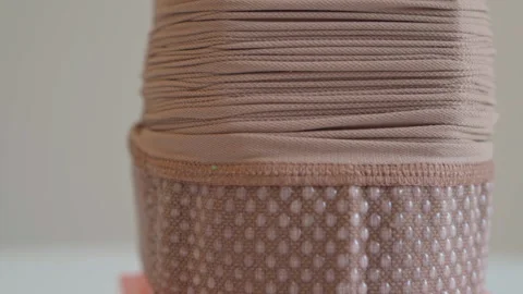 Closeup texture of compression stocking stretched on assist device surface Stock Footage 321709572