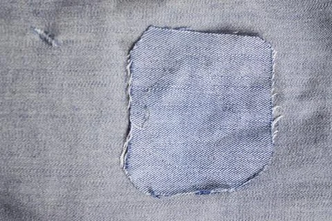 Closeup texture of light blue denim jeans with a stitched fabric patch for .. Foto stock