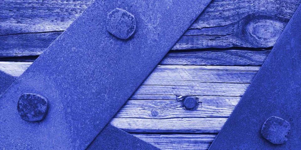 Closeup texture of rusty iron sheets bolted to aged wooden planks in blue colors Stock Photos
