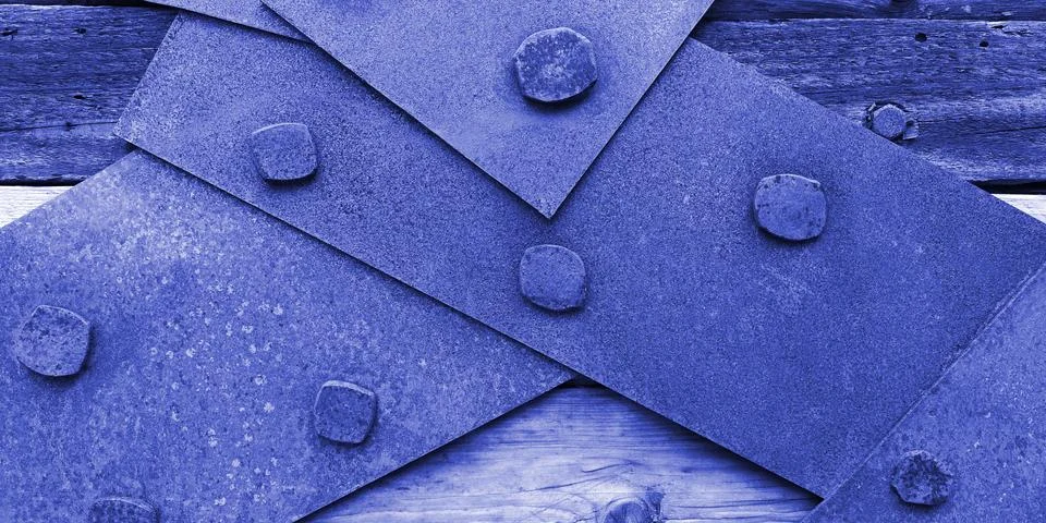 Closeup texture of rusty iron sheets bolted to aged wooden planks in blue colors Stock Photos