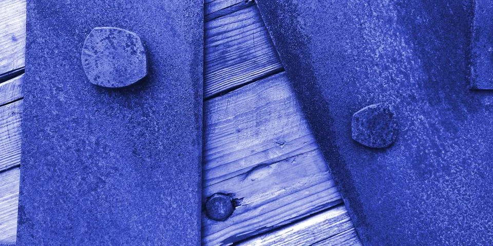 Closeup texture of rusty iron sheets bolted to aged wooden planks in blue colors Stock Photos