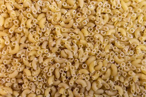 Closeup texture of uncooked elbow macaroni pasta food background Fotos de archivo