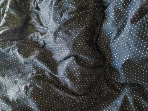 Closeup of textured dark fabric with a subtle polka dot pattern.  The wrinkle Foto stock