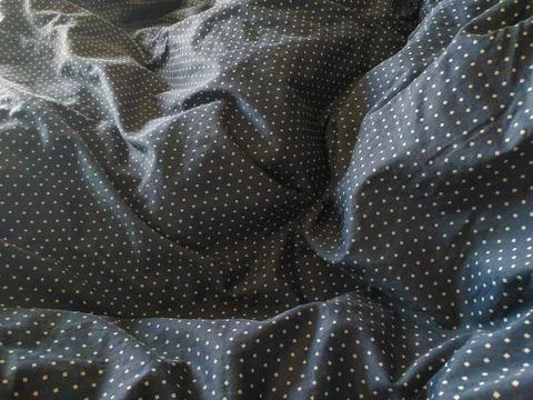 Closeup of textured dark fabric with a subtle polka dot pattern.  Soft, drape Stock Photos