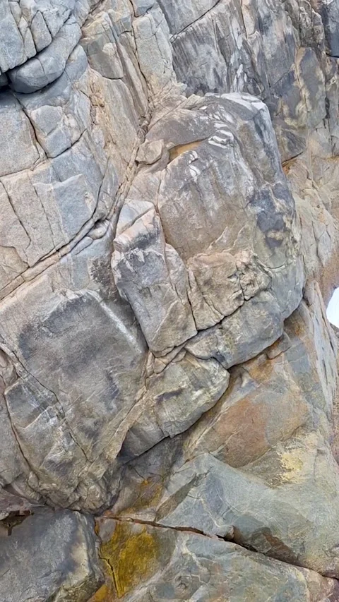 Closeup of textured granite rock face with natural cracks and fractures Video stock 335654074