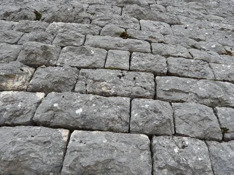 Closeup of a textured stone wall, featuring its rough and aged surface Stock Photos