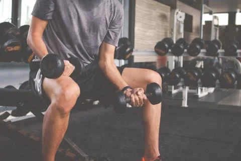 Closeup of a thin man doing exercises with dumbbell. Fitness muscular body. F Foto stock