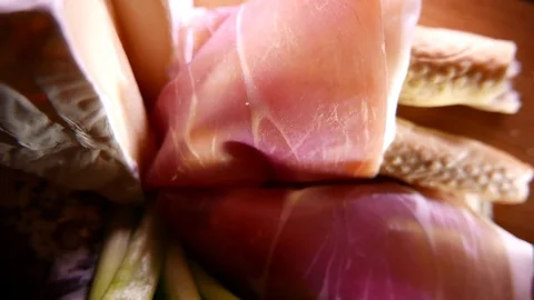 Closeup of thin slices of pork ham on the dish with cheese and greens. 4K UHD Vídeo Stock 73047305