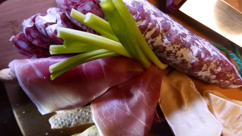 Closeup of thin slices of pork ham on the dish with cheese and greens. 4K UHD Stock Footage 73047689