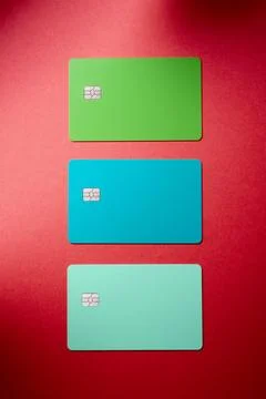 Closeup of three multicolored microchip debit cards on a red desk. Stock Photos