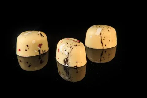 Closeup three small oval-shaped white chocolate candies Fotos de archivo