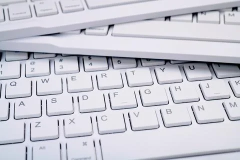 Closeup of three white computer keyboards with a wireless connection Stock Photos