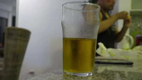 Closeup throwing a potato chip into a glass of beer in the kitchen in 4k Stock Footage 194501207