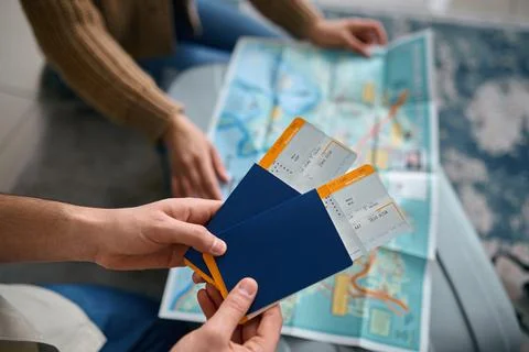 Closeup ticket in hand over guide map Fotos Stock