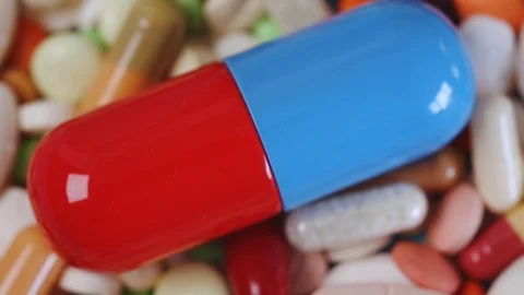 Closeup tilt view of large pill among many colorful pills Stock Footage 97053739