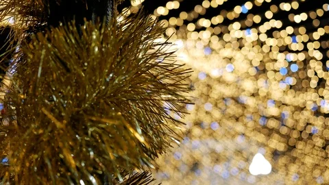 Closeup of tinsel on pole on background light garland Christmas tree. Copy space Stock Footage 122297482