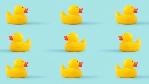 Closeup of tiny duck toys moving against a blue background Vídeos de archivo 221490915