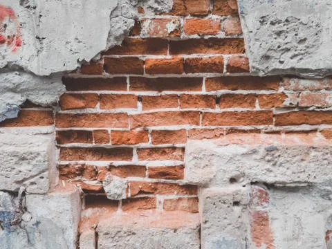 Closeup toned texture of falling off plaster from cracked brick wall Stock Photos