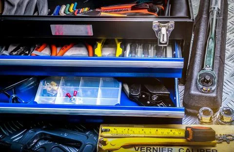 Closeup of tools in box on checkered plate background in workshop. Service .. Stock Photos