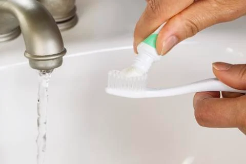 Closeup of tooth paste being placed on tooth brush Stock Photos