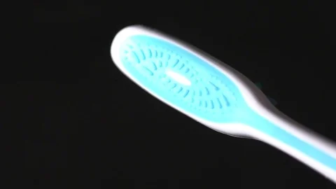 Closeup of toothbrush on the black background slow motion Stock Footage 76215419
