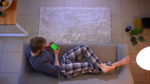 Closeup top shoot of young casually dressed male watching an advertisement on Video stock 106947547