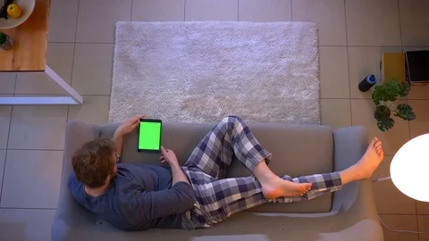 Closeup top shoot of young casually dressed male watching an advertisement on Stock Footage 106950079