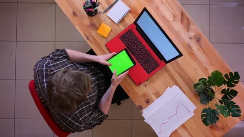 Closeup top shoot of young caucasian businessman using the tablet with green Video stock 107004591
